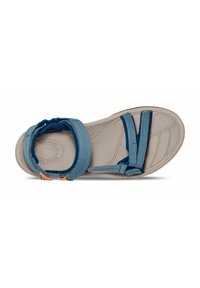 Sandalia de tela azul con múltiples correas y una suela beige. Incluye características como una plantilla texturizada y cierres ajustables para un ajuste seguro.