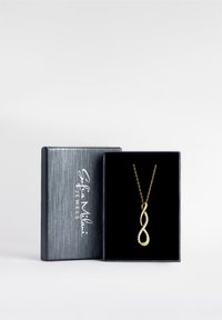 Collana con pendente infinito in oro dal design elegante e morbido, caratterizzato da una spirale, arricchito da una fila di piccoli gemme trasparenti, presentato in una scatola nera di velluto.