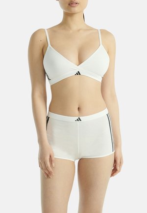 Witte bralette en shorts met zwarte accenten aan de zijkanten. Zacht materiaal, driehoekig ontwerp van de bralette, fijne banden, elastische tailleband op de shorts.