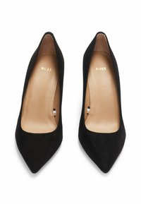 Paire d’escarpins pour femme en daim noir à bout pointu avec semelles intérieures en cuir brun clair marquées « BOSS », vue de dessus sur fond blanc.