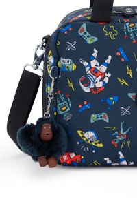 Borsa in tessuto blu navy con illustrazioni colorate a tema spaziale; dotata di una tracolla nera e un portachiavi a forma di scimmietta pelosa.