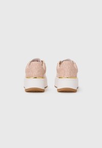 Pair of pink platform sneakers with beige MK monogram pattern, white thick soles, and gold accent on heel, viewed from the back.