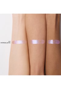 Drie armen die staalkaartjes van een glinsterend iriserend product in lichtpaars tonen, aangebracht op verschillende huidtinten met het label "217 INTERGALACTIC."