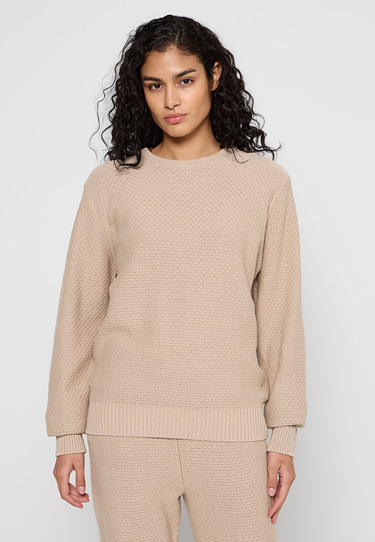 Beige gestrickter Pullover mit strukturiertem Muster, Rundhalsausschnitt, langen Ärmeln und geripptem Saum. Lässige Passform, kombiniert mit passenden Hosen.