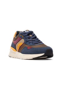 Zapatilla multicolor con parte superior en azul marino y acentos en marrón y burdeos, tejido texturizado, punta redondeada y suela acolchada.