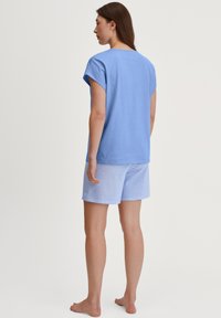 Lichtblauw katoenen t-shirt met korte mouwen, gecombineerd met lichtblauwe en witte gestreepte shorts. Glad textuur, casual ontwerp en een relaxte pasvorm.