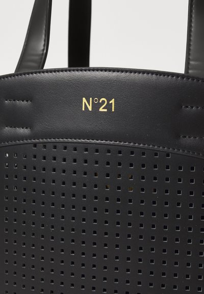 Svart perforerad läderhandväska med fyrkantiga utskärningar, med en guldpräglad "N°21"-logotyp på framsidan, släta svarta handtag.