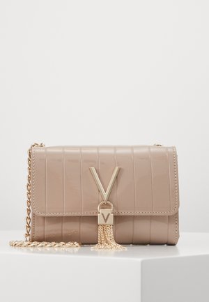 Sac bandoulière en cuir beige avec coutures verticales, bandoulière chaîne dorée, et fermoir en forme de V doré avec chaînes à pampilles pendantes.