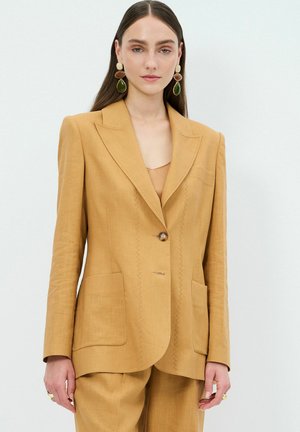 Hořčicově žlutý blazer se strukturovaným designem, zapínáním na jeden knoflík, dvěma předními kapsami a jemnými švy.