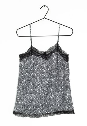 Vestido camisola negro y blanco con estampado floral y ribete de encaje en el escote y el dobladillo, colgado en una percha fina negra sobre un fondo blanco.