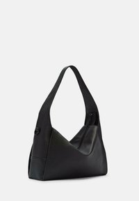 Czarna skórzana torba na ramię o unikalnym trójkątnym kształcie, teksturowanej powierzchni i zamknięciu na zamek. Posiada szeroki, wygodny pasek na ramię.