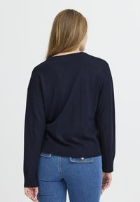 Dunkelblauer Strickpullover mit Rundhalsausschnitt, gerippten Bündchen und Saum. Bietet eine lockere Passform und strukturierte Schulterdetails.