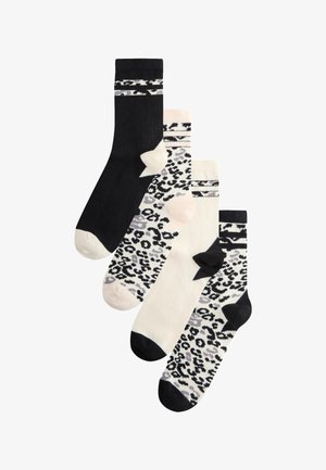 Vier Paar knielange Socken in Schwarz und Weiß mit Leoparden- und Streifenmustern, auf weißem Hintergrund überlappend angeordnet.