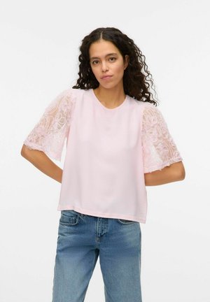 Lys pink top med korte, teksturerede spids ærmer. Rund udskæring, afslappet pasform. Blødt materiale og delikat blomster-spids detalje på ærmerne.