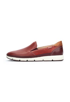 Zapatillas rojas de tipo slip-on hechas de cuero texturizado con un tacón de cuero liso. Cuentan con una suela de goma blanca y un diseño perforado para mayor transpirabilidad.