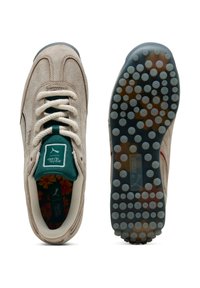 Sneakers beige in suede con una parte superiore testurizzata, foderati in tessuto verde, con soletta floreale e suola in gomma con puntini. Presentano lacci crema e strisce laterali.