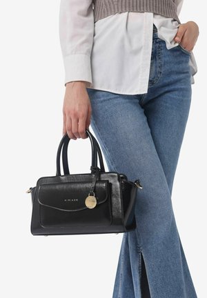 Borsa a mano in pelle nera con un design strutturato, dettagli in hardware dorato, manici superiori e una tasca frontale con un charm circolare.
