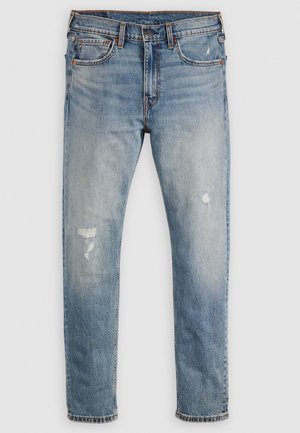 Jeans en denim bleu clair avec une coupe droite, présentant des patchs décolorés et de petites zones usées près des genoux. Design classique à cinq poches.