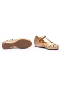 Gouden leren schoenen met uitsnijdingen en gevlochten accenten. Voorzien van een lage wigzool met een textuur voor grip en traction.