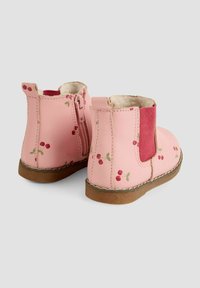 Botas de tobillo de cuero rosa con patrones de cerezas, paneles laterales elásticos y cierre de cremallera. Forro suave y suela de goma para mayor comodidad.
