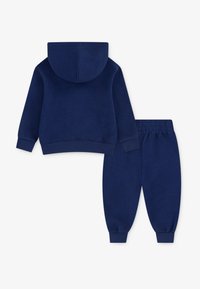 Marineblå bomulds hoodie med hætte og ribbede manchetter, parret med matchende joggerbukser med elastisk talje og tætsiddende ankler.