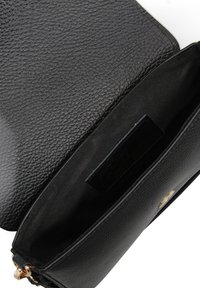 Borsa a mano in pelle nera con esterno testurizzato, hardware in tonalità oro e interno in tessuto nero liscio con etichetta del marchio.