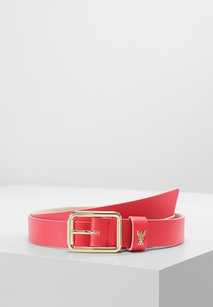 Ceinture en cuir rouge avec une boucle rectangulaire dorée et un petit logo lapin doré sur la boucle, présentée sur une surface blanche.