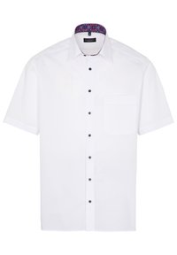 Camisa blanca de manga corta hecha de tejido suave con botones oscuros y un cuello interior estampado que presenta acentos en azul y rojo. Un bolsillo en el pecho.