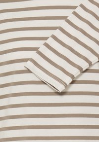 Top de manga larga a rayas en algodón beige y blanco, con rayas horizontales uniformemente espaciadas y escote redondo con dobladillos cosidos.