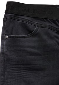 Svarta jeans i denim med en mjuk textur, framficka och ett brett midjeband med präglad märkning. Silvriga detaljer på fickan.