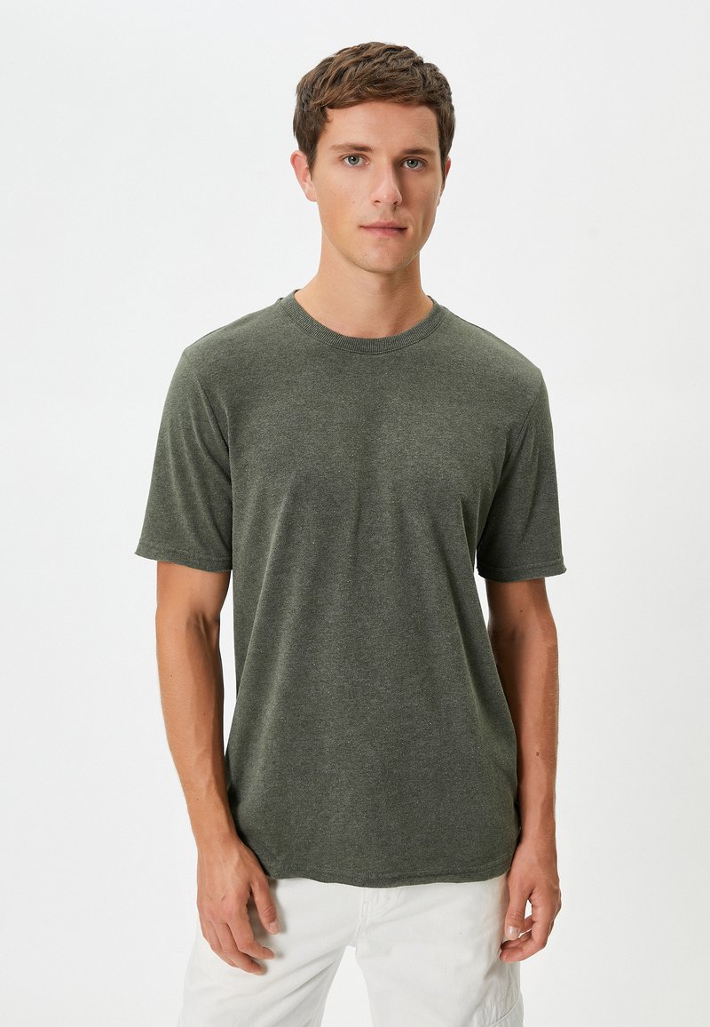 Kortärmad t-shirt med rund halsringning i melerad olivgrön tyg. Enkel design, mjuk textur, avslappnad passform, inga synliga mönster eller detaljer.