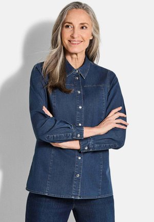 Dunkelblaue Jeanshemd mit Knopfverschluss, Kentkragen und langen Ärmeln. Verfügt über Nähte und Druckknöpfe zum Schließen. Weiche Textur.