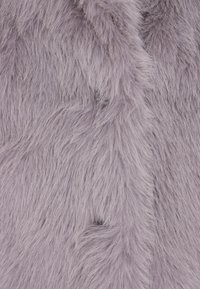 Plush lilla falsk pels stof med lange, bløde fibre. Teksturen er tyk og fluffy, med en subtil glans og naturlige farvevariationer.
