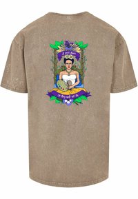 Brown cotton T-shirt featuring a colorful graphic of a seated figure with a paint palette, surrounded by flowers and decorative text.