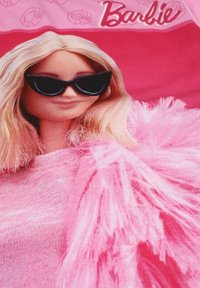 Poupée Barbie avec de longs cheveux blonds ondulés, portant de grandes lunettes de soleil noires et un châle rose et duveteux sur un haut rose scintillant.