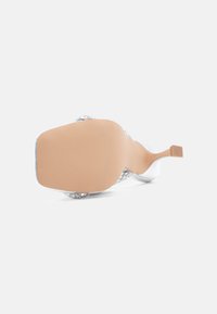 Διαφανές σανδάλι με ανοιχτή μύτη, ασημένιες λεπτομέρειες στο πάνω μέρος και μπεζ υφασμένη σόλα. Ο σχεδιασμός περιλαμβάνει διακοσμητικούς ιμάντες και λεπτό τακούνι.