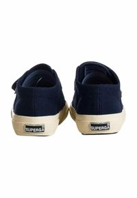 Sneakers in tela blu navy con una finitura testurizzata, suole in gomma bianca e una patch con il marchio sul tallone. Design classico a profilo basso.