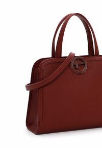 Rød struktureret lædertaske med to robuste øverste håndtag, en aftagelig skulderrem og en cirkulær metalaccents på fronten.