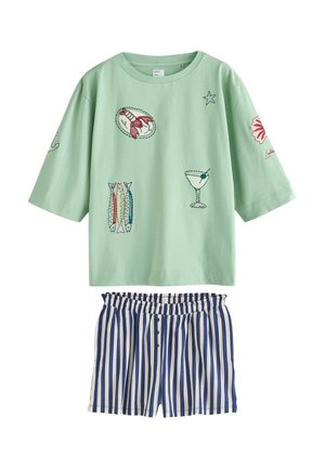 Hellgrünes, übergroßes Hemd mit Stickerei von Meeresfrüchten und Cocktails, kombiniert mit blau-weiß gestreiften Shorts mit senkrechten Streifen und Knöpfen.