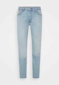 Jasnoniebieskie dżinsy o slim fit, z pięcioma kieszeniami i delikatnym wyblakłym przodem. Brak widocznych znaków towarowych lub ozdób.