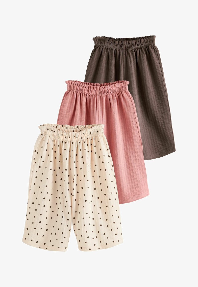 Tre par shorts med elastik i taljen i brun, pink og hvid med sorte polkaprikker, arrangeret overlappende på en hvid baggrund.