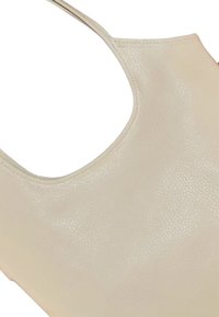 Lichtbeige tote bag gemaakt van gestructureerd faux leather, met een gebogen bovenkant en een zachte, gladde textuur, zonder zichtbare accessoires.