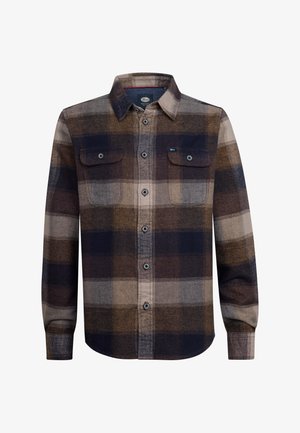 Chemise en flanelle à carreaux dans des tons marron, bleu marine et gris, avec deux poches poitrine. Un pantalon vert olive et des bottes beiges complètent la tenue.