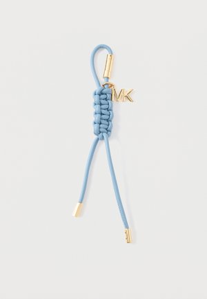 Jasnoniebieski pleciony skórzany brelok z metalowymi złotymi nasadkami i złotym zawieszkom "MK" na białym tle.