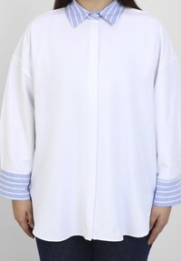 White shirt with a light blue striped collar and cuffs. Made of smooth fabric, featuring a button-down front and long, loose sleeves.