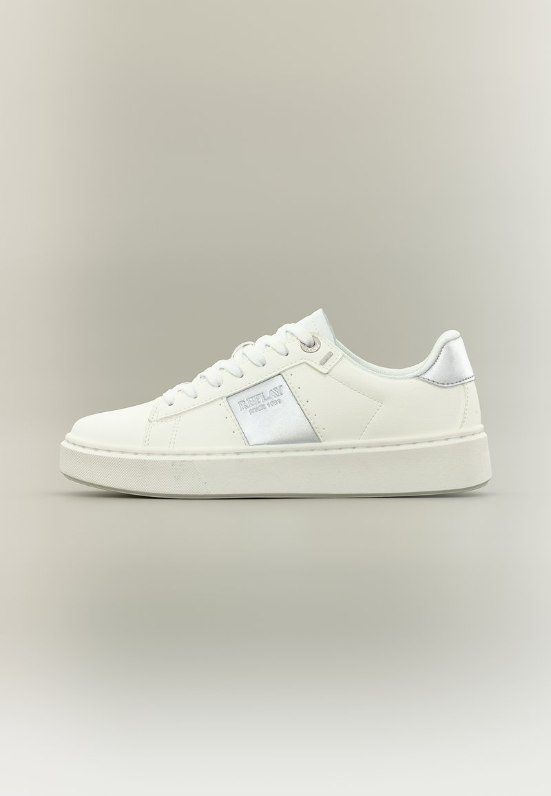 Baskets basses blanches avec lacets blancs, languette argentée au talon, et panneau latéral arborant le logo de la marque "Replay" en argent.