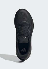 Chaussure de sport noire avec une tige en maille respirante, des lacets plats, un col rembourré et une semelle texturée. Équipée du logo emblématique des trois bandes.