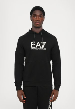 Black hooded sweatshirt featuring a large white EA7 Emporio Armani logo on the front. Made from soft fabric with a kangaroo pocket.