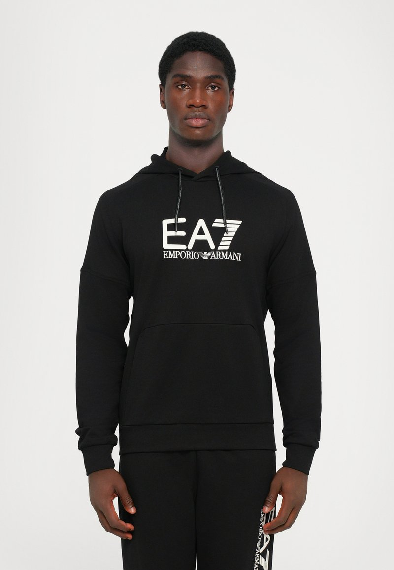 Felpa nera con cappuccio caratterizzata da un grande logo bianco EA7 Emporio Armani sulla parte anteriore. Realizzata in morbido tessuto con tasca a marsupio.