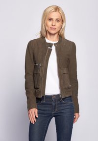 Olijfgroene leren jas met een ronde halslijn, voorrits en twee zijzakken. Gladde textuur, slim fit ontwerp en minimale details.